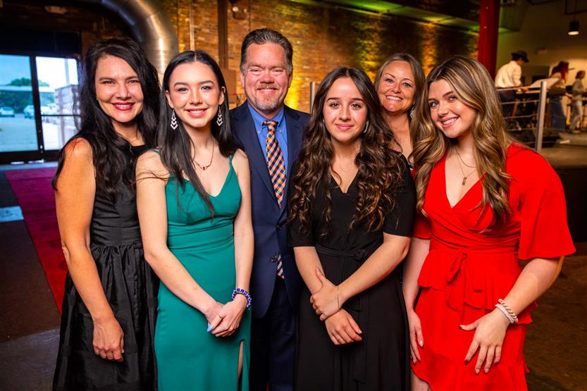 A group of women and a man smile